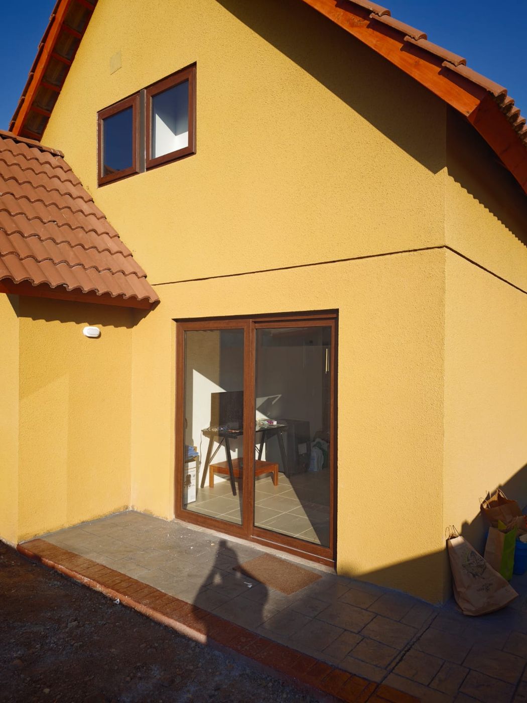 Casa con ventanas y puerta corredera de PVC nogal