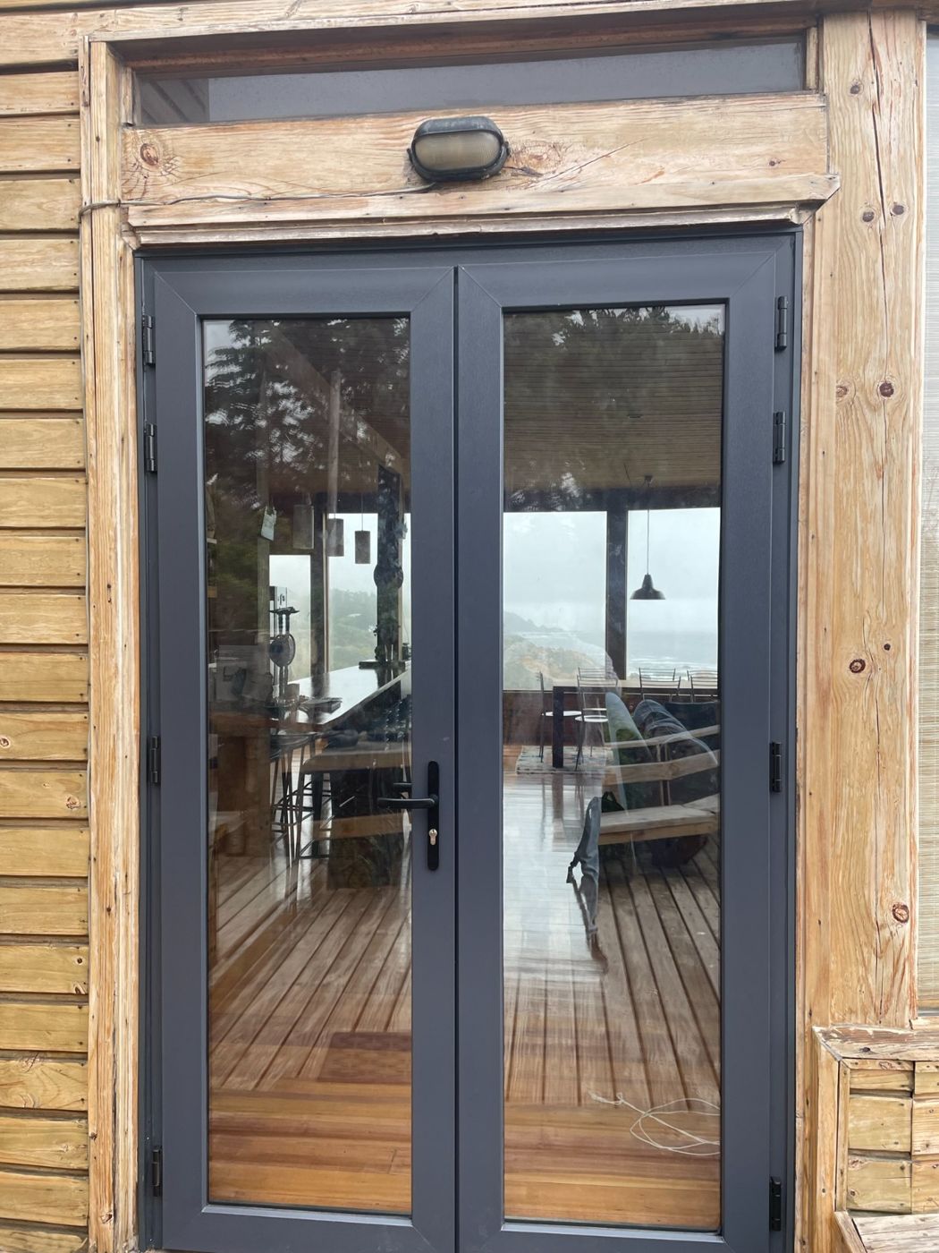 Puerta doble de PVC antracita en casa de madera