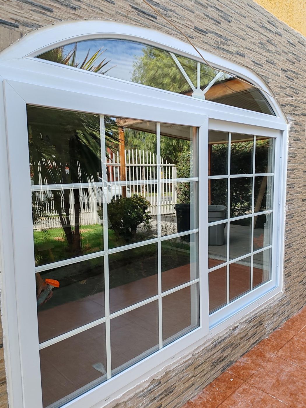 Ventana corredera de PVC blanca con arco superior